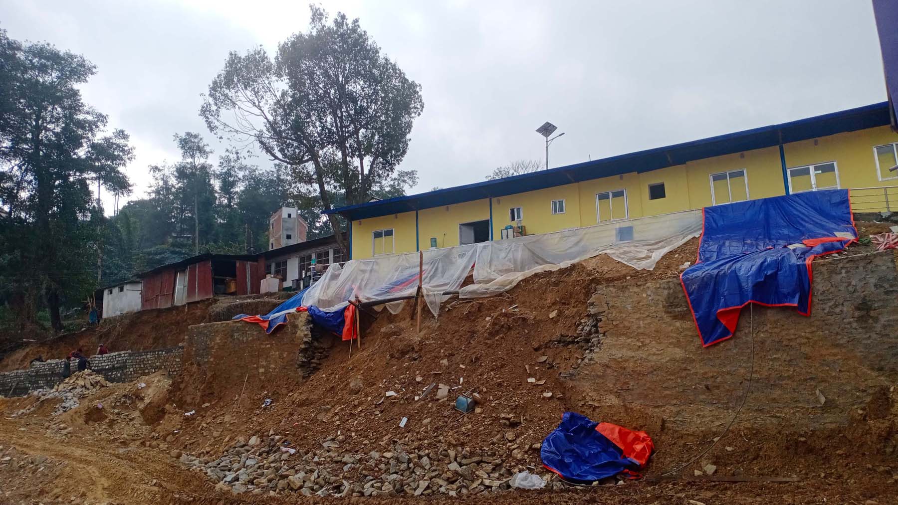 निर्माणाधीन अस्पतालको टेवा पर्खाल लगाइ नसक्दै भत्कियो
